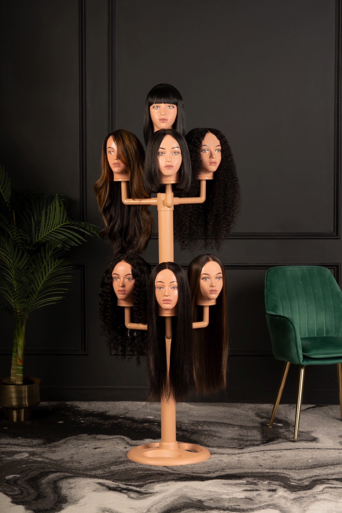 The wig hanger with 7 worn mannequin heads in a dark and cosy living room.