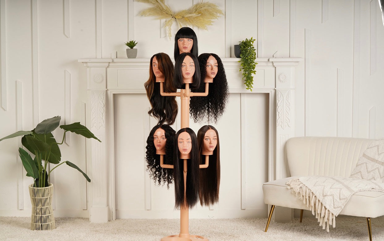The wig hanger with 7 worn mannequin heads in a cream and cosy living room.