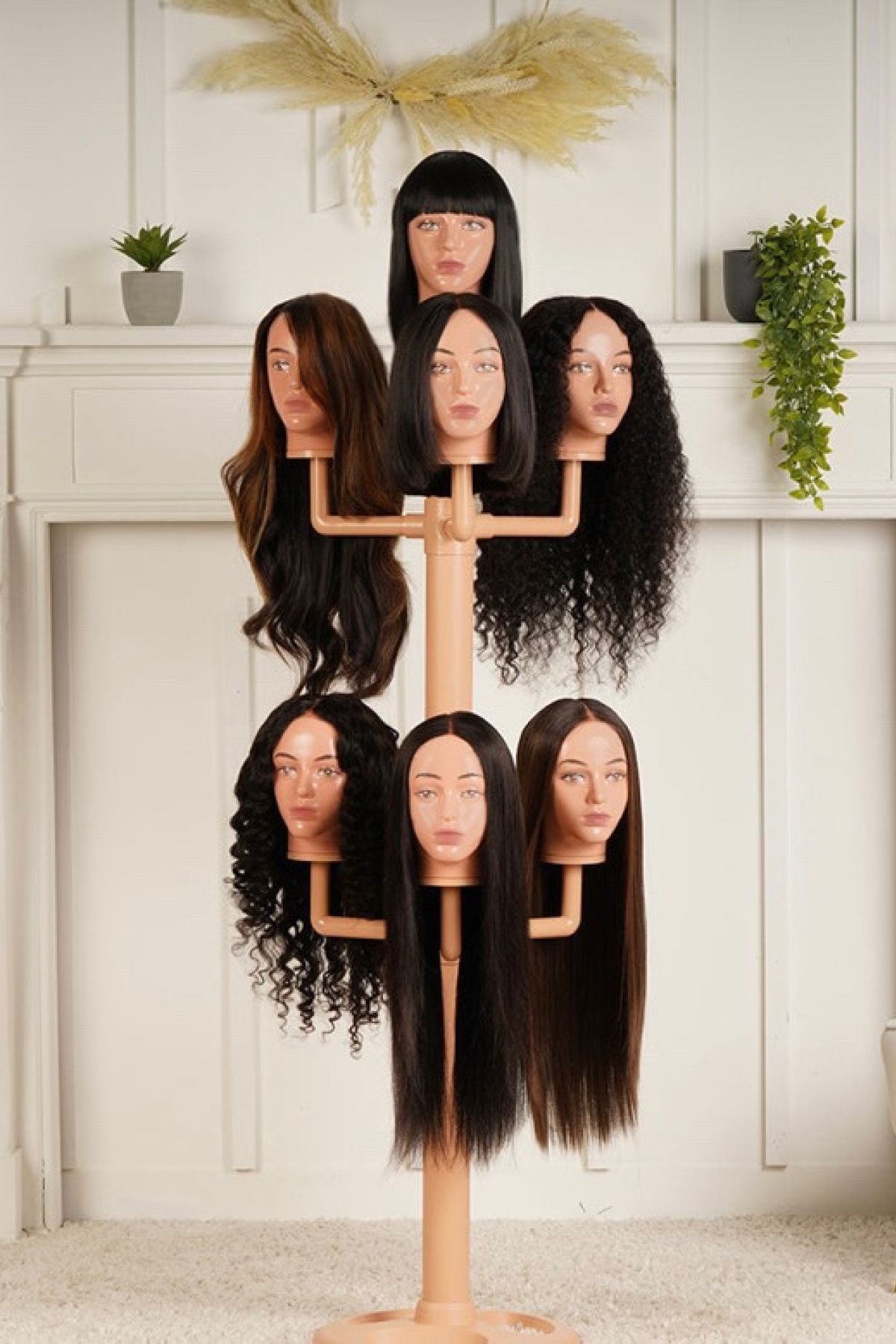 The wig hanger with 7 mannequin head worn with wigs in a living room.